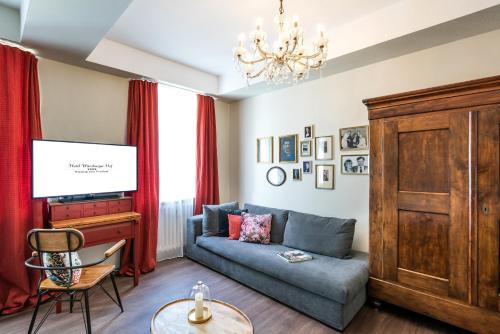 a living room with a couch and a tv at Hotel Würzburger Hof **** in Würzburg