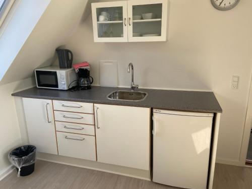 a kitchen with a sink and a microwave at Oasen Samsø in Nordby