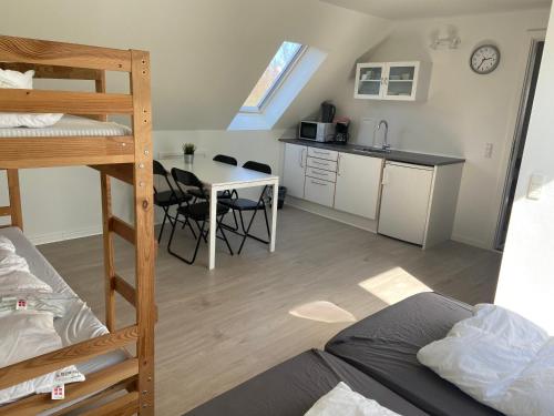 a room with a bunk bed and a kitchen with a table at Oasen Samsø in Nordby