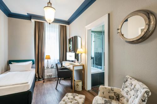 a hotel room with a bed and a desk at Hotel Würzburger Hof **** in Würzburg