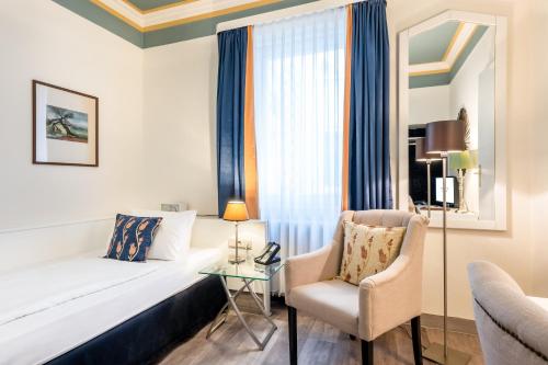 a hotel room with a bed and a chair at Hotel Würzburger Hof **** in Würzburg