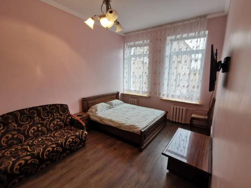 sala de estar con sofá, cama y ventana en Cietokšņa 34 en Daugavpils