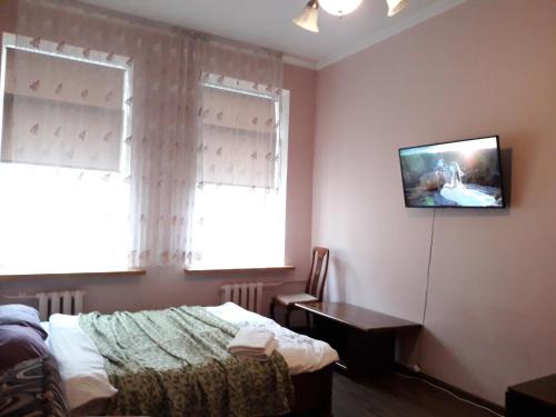 a bedroom with a bed and a tv on the wall at Cietokšņa 34 in Daugavpils