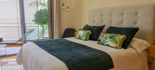 een slaapkamer met een groot bed met groene kussens bij Apartamento El Atardecer in Tazacorte