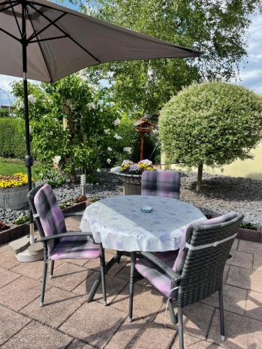 a table and two chairs with an umbrella at gemütliches, freistehendes Ferienhaus in Koblenz