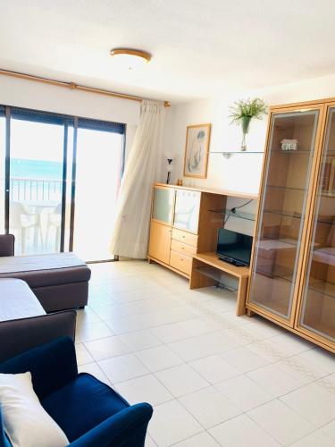 a living room with a couch and a large window at Apartamento Playa Peñíscola in Peniscola