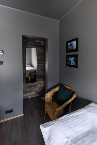 a bedroom with a bed and a chair and a mirror at Acco Luxury Apartments in Akureyri