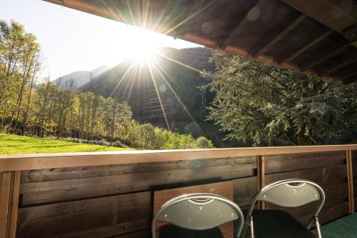 two chairs on a porch with a view of the mountains at Haus Stüttler/Duchscherer in Schruns-Tschagguns