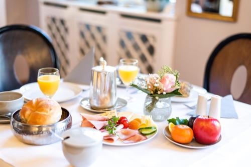 a table with a plate of fruit and orange juice at Hotel Würzburger Hof **** in Würzburg
