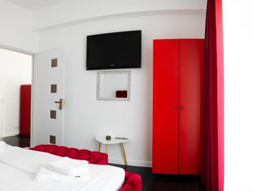 sypialnia z czerwonymi szafkami i telewizorem na ścianie w obiekcie Solemar Boutique w mieście Eforie Sud