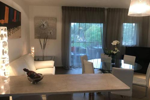 une salle à manger et un salon avec une table et des chaises dans l'établissement Appartement à 50 mètres de la plage, à Zonza
