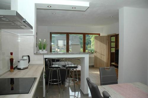 a kitchen with a counter and stools in it at Ferienwohnung-Bine am Nürburgring in der Eifel in Quiddelbach