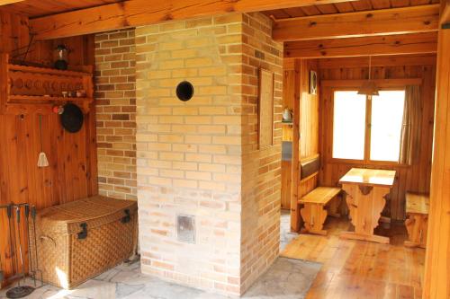 un camino in mattoni in una camera in legno con finestra di Chata Urbaneč a Urbaneč
