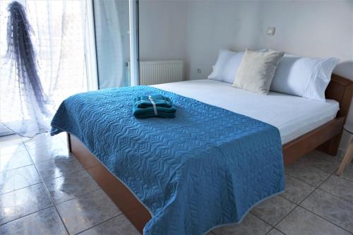 a bed with a blue blanket and two towels on it at Katerinas House in Nikiti