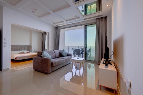 斯利马Luxurious Apt with Ocean Views and Pool in Tigne Point的带沙发和桌子的客厅