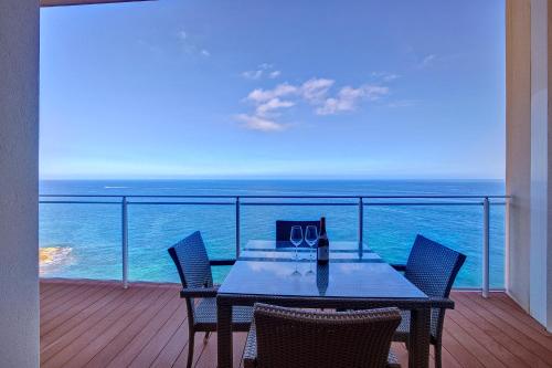 a table on a balcony with a view of the ocean at Luxurious Apt with Ocean Views and Pool in Tigne Point in Sliema