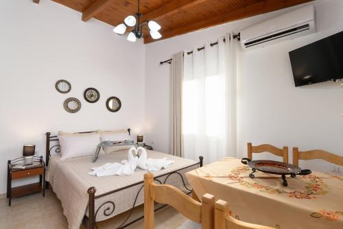 a bedroom with two beds and a tv and two tables at Anastasia's House 2 in Plátanos