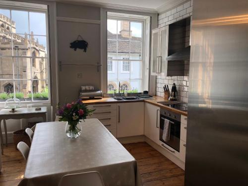 a kitchen with a table with a vase of flowers on it at St Martins Apartment Stamford in Stamford