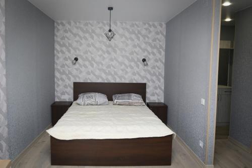 1 dormitorio con 1 cama con espejo grande en Путивль Квартира студия en Putyvlʼ
