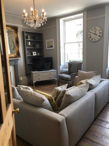 a living room with a couch and a clock on the wall at St Martins Apartment Stamford in Stamford