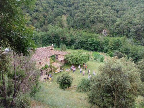 a group of people walking in a field next to a building at Bed and Breakfast Casanova de Sant Miquel in Aiguafreda