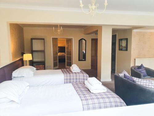 two beds in a hotel room with towels on them at The Albany St Andrews in St. Andrews