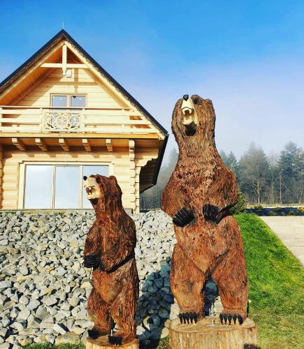 two bear statues in front of a house at Wioska Jasia i Małgosi in Izdebnik