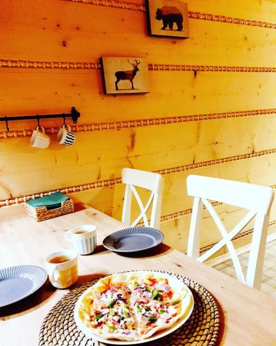 a pizza sitting on top of a table with two chairs at Wioska Jasia i Małgosi in Izdebnik