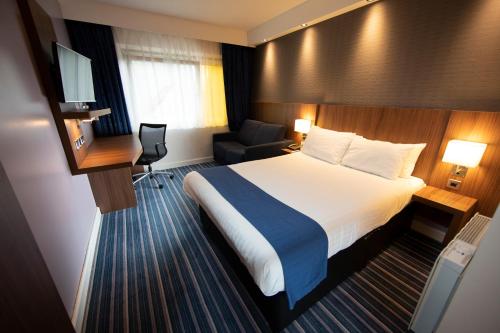 a hotel room with a bed and a chair at Holiday Inn Express, Chester Racecourse by IHG in Chester