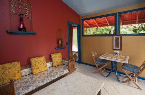 a living room with a couch and a table and chairs at Hawaiian Balinese Temple House in Pahoa