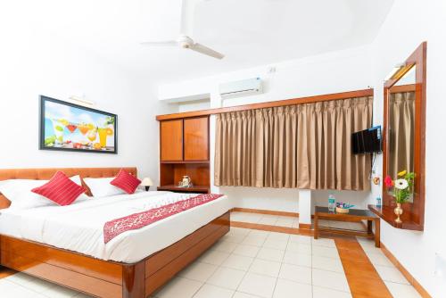 een slaapkamer met een groot bed en een televisie bij Hotel Green Field in Satara