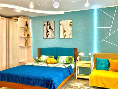a bedroom with a bed and a blue wall at Cozy studio in Vinnytsya