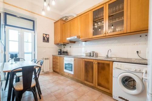 a kitchen with a washing machine and a table at Cosy Apartment Near the Center in Lisbon