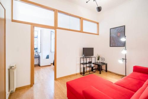 a living room with a red couch and a table at Cosy Apartment Near the Center in Lisbon