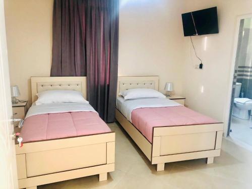 dwa łóżka siedzące obok siebie w sypialni w obiekcie R HOTEL w mieście Çorovodë