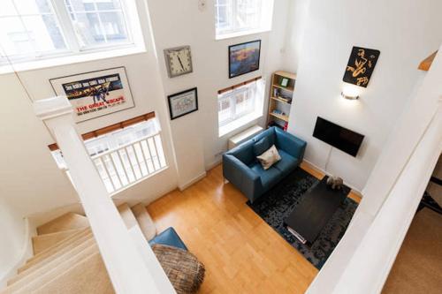 una vista aérea de una sala de estar con un sofá azul en Central 2-Bed, 2-Bath Sanctuary near Holborn Station, Covent Garden & West End, en Londres