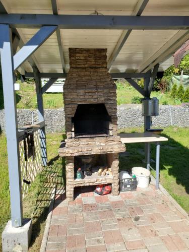 una chimenea de piedra bajo un techo con una mesa de picnic en Casa Marian, en Sighişoara