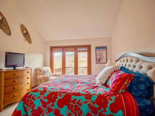 a bedroom with a bed and a dresser and a television at C3 Crawford Ridge Townhome with Mt Washington views - just a short walk from ski lodge and slopes in Carroll
