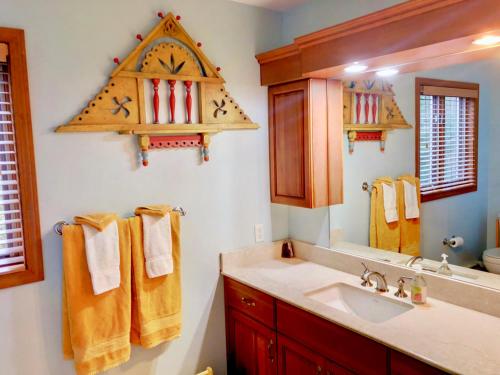 a bathroom with a sink and a clock on the wall at C3 Crawford Ridge Townhome with Mt Washington views - just a short walk from ski lodge and slopes in Carroll