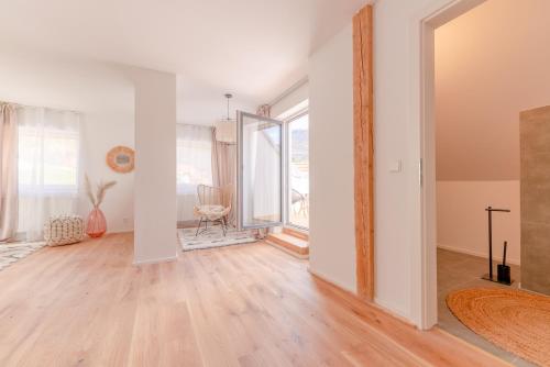 un soggiorno vuoto con pavimenti in legno e una camera con finestra di Dach.Loft Spitz in der Wachau a Spitz
