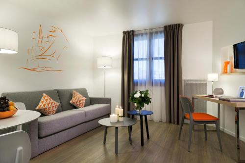 a living room with a couch and a table at Citadines Presqu'île Lyon in Lyon