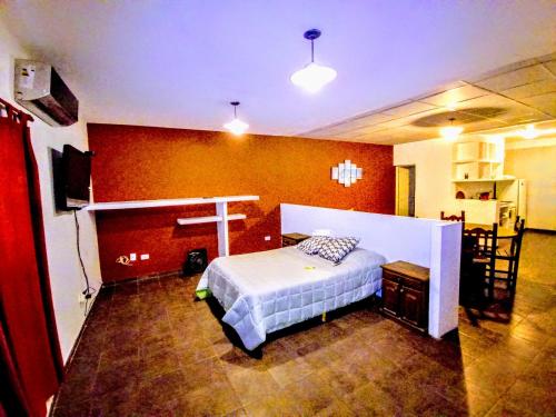 een slaapkamer met een bed en een rode muur bij Departamento La Morenita in Chilecito