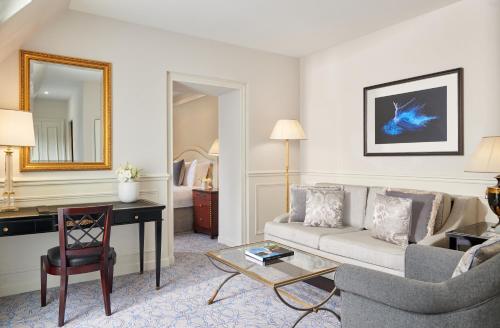 a living room with a couch and a desk in a hotel room at InterContinental Paris Le Grand by IHG in Paris