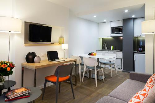 a kitchen and living room with a table and chairs at Citadines Presqu'île Lyon in Lyon