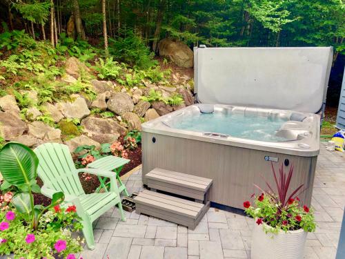 a jacuzzi tub with a chair and a chair at E5 Beautiful Bretton Woods slopeside home amazing views of Mount Washington Hot Tub AC in Carroll