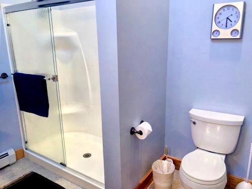 a bathroom with a shower with a toilet and a clock at E5 Beautiful Bretton Woods slopeside home amazing views of Mount Washington Hot Tub AC in Carroll