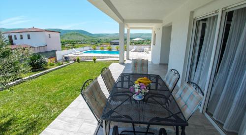 - une table et des chaises sur une terrasse avec piscine dans l'établissement Villa Buna Breeze, à Blagaj