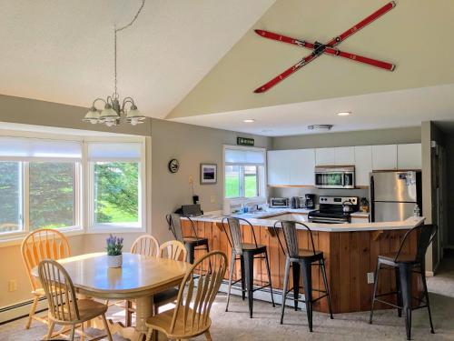 a kitchen and dining room with a table and chairs at F3 Fairway Village Condo with great mountain views, 8 minute walk from Omni Mount Washington Hotel! in Carroll