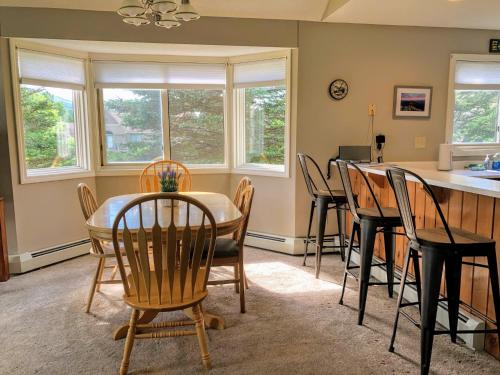 a kitchen and dining room with a table and chairs at F3 Fairway Village Condo with great mountain views, 8 minute walk from Omni Mount Washington Hotel! in Carroll