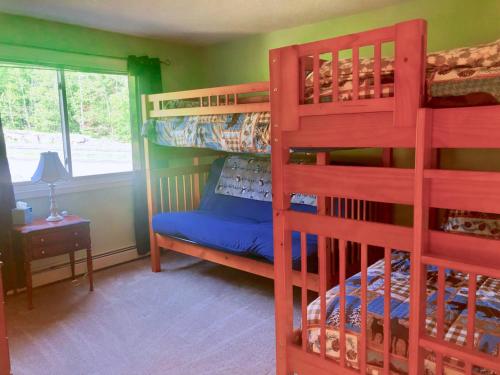 a bedroom with two bunk beds and a window at F3 Fairway Village Condo with great mountain views, 8 minute walk from Omni Mount Washington Hotel! in Carroll